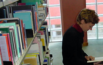 Person looking at book in the Main Library. 