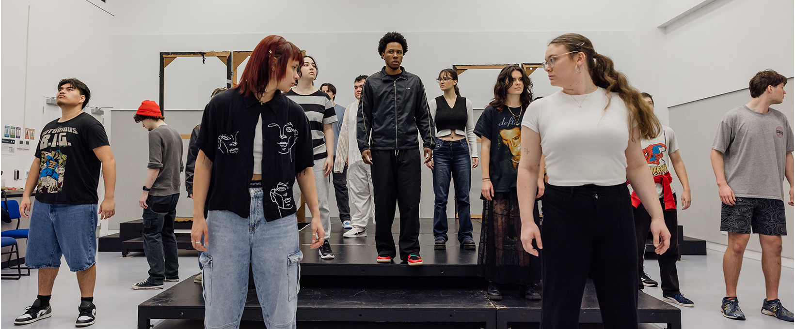Group of acting student pose while rehearsing a stage production