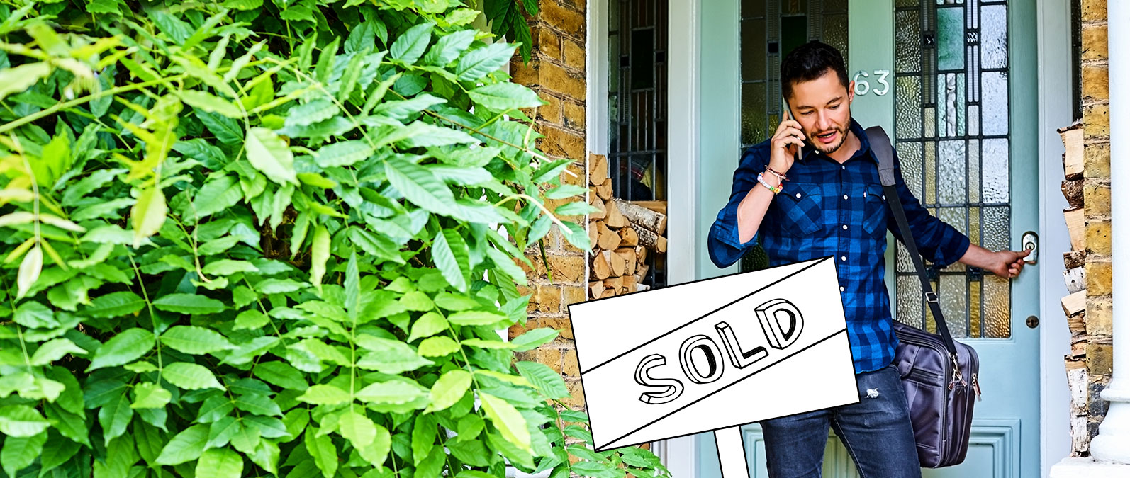 Real estate agent walks out the front door of a house while talking on mobile phone