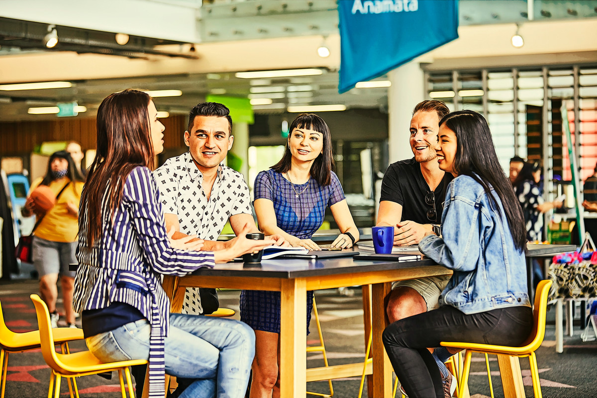 International students gathered at a table inside Unitec's vibrant tudent hub