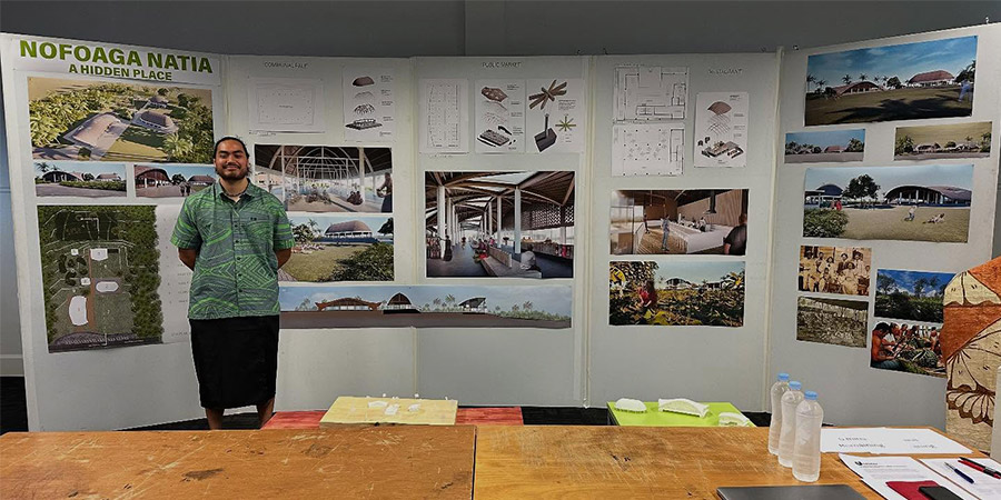 Ethan Hansell-Hunt stands in fron tof dispaly board shoing his project - Nofoaga Natia-A Hidden Place