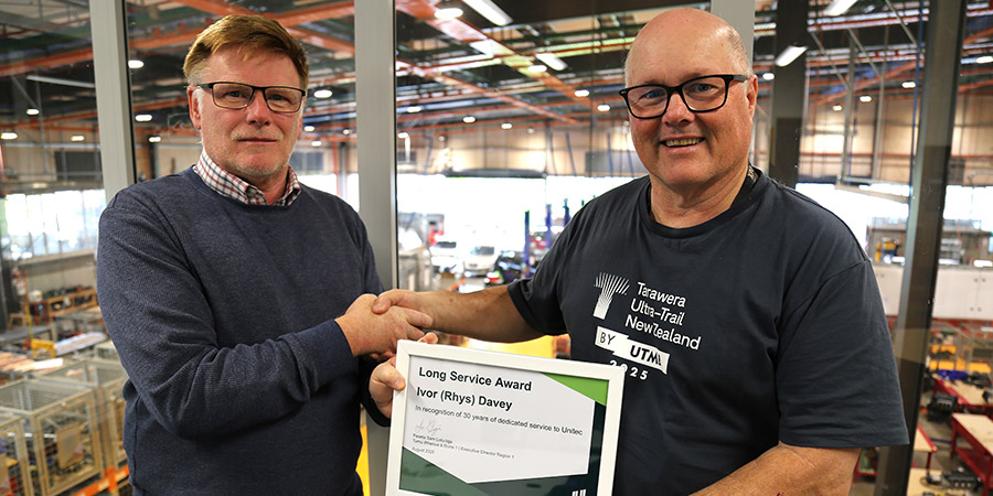 Lee Baglow presents Rhys Davey a long service corticate while shaking hands