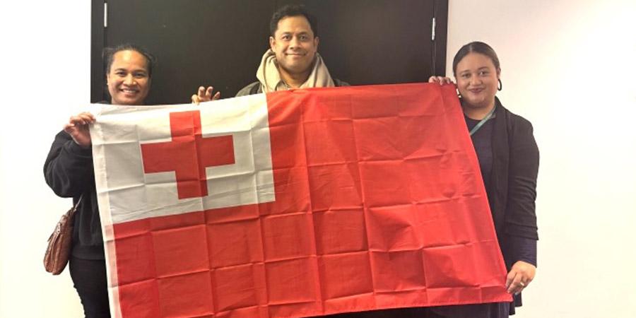 Three members of Unitec’s Tongan language week Komiti prouldy hold the Tongan flag