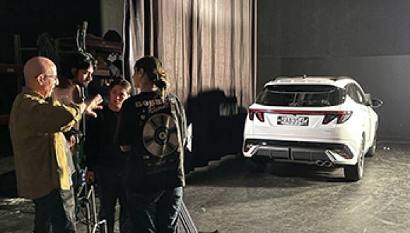 Performing and Screen Art students set up the film studio for the shoot while moving the TUCSON Hybrid Series II Into position