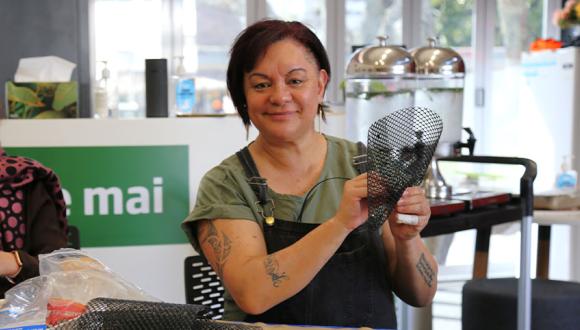Tonina Ngatai proudly holds up a woven artifact