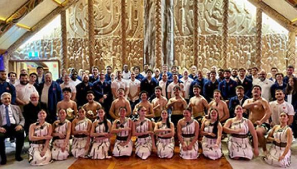 Le XV de France rugby team pose with kapa haka group from Ngā Puna o Waiorea and Unitec staff inside the whare nui at Te Noho Kotahitanga marae