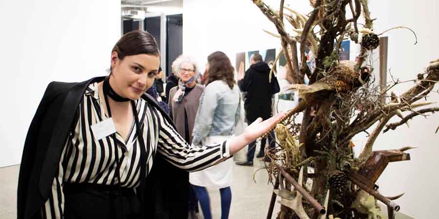Michaela van Laan poses with her wooden sculpture.