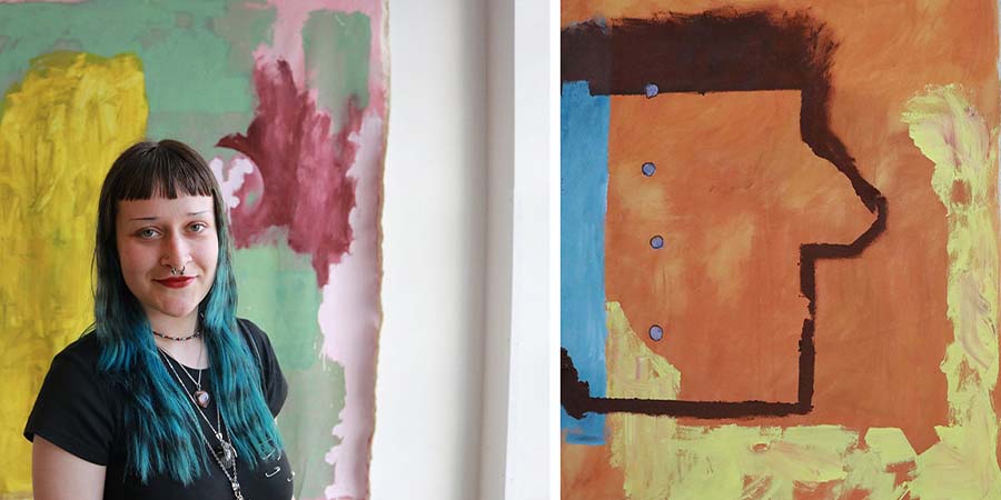 Mara Szkely stands in front of some of her colourful abstract paintings. 