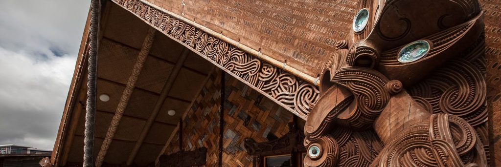 Wooden carvings on the exterior Te Noho Kotahitanga marae, with inlaid paua shell. 