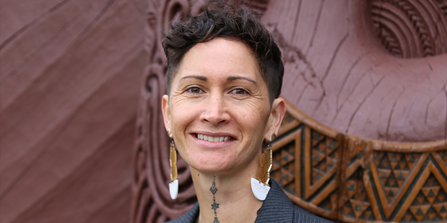 Associate Professor Deb Heke, a wāhine Māori, smiles in front of the Unitec Marae.
