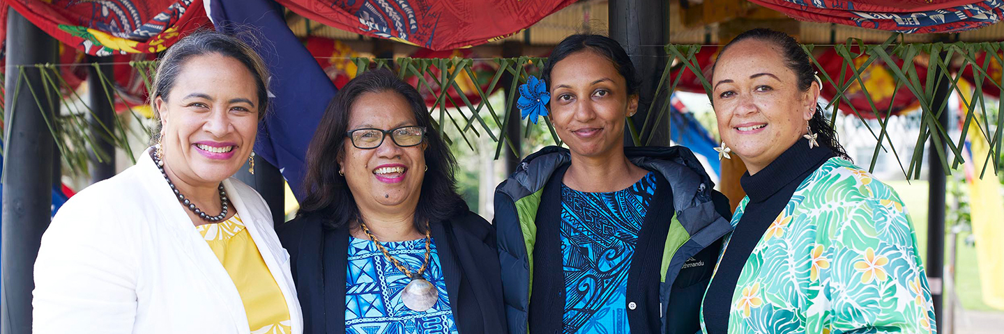 Four smiling Unitec staff attend an event at the Fale