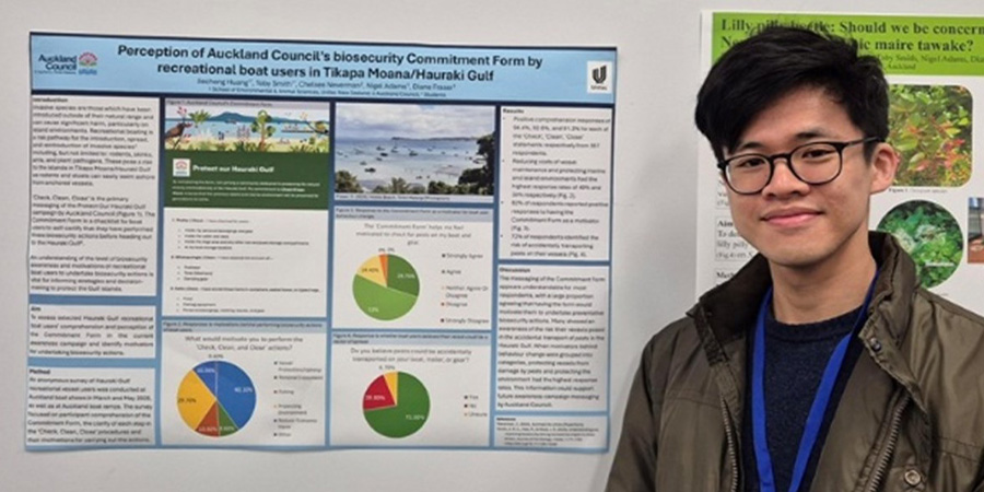 Jay Huang in front of the biosecurity poster he created for NETS.