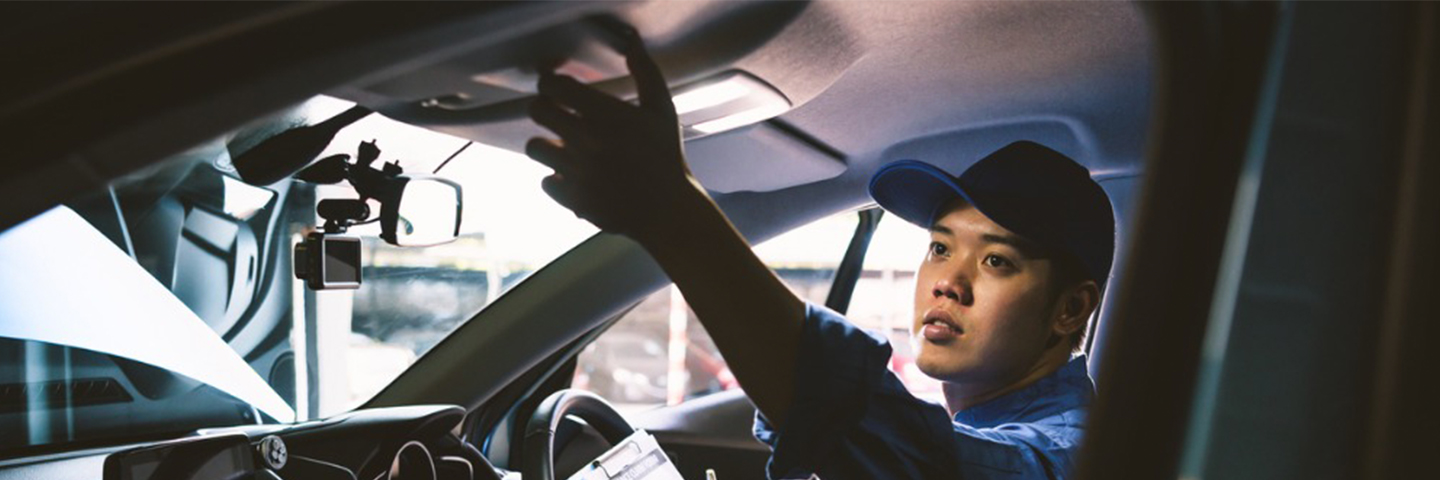 Mechanic doing a vehicle inspection inside a car