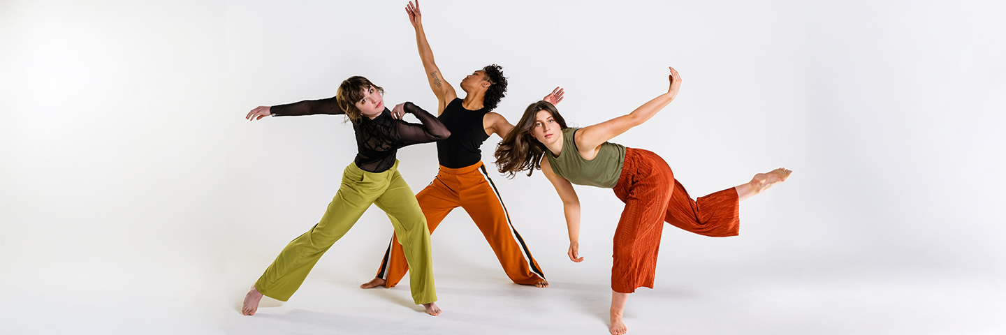 Three contemporary dancers pose with expression