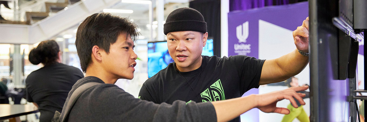 Unitec staff help a visitor with their question at an open day event