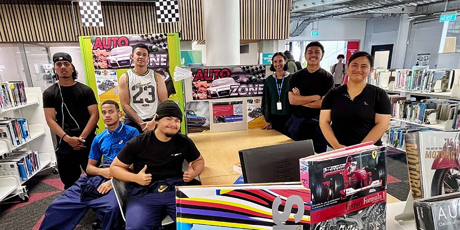 Students pose in the Auto Zone for a photo.