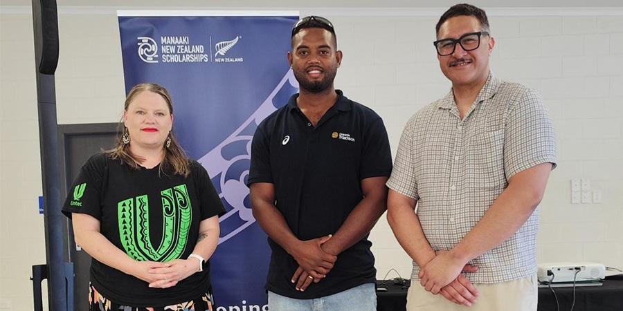 Boris Teddy smiles as he stands with two Unitec scholarship team members