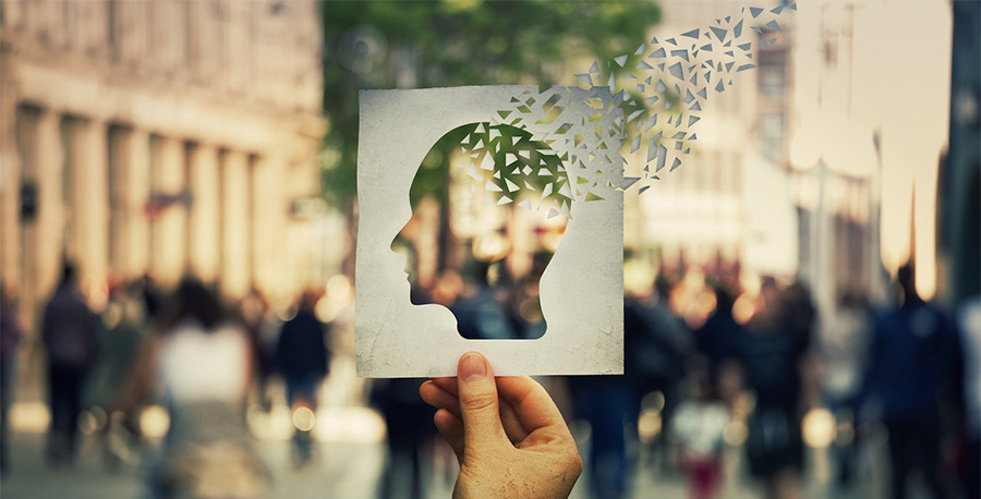 A hand holding a silhouette of a human head.