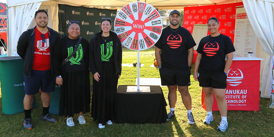 MIT and Unitec kaimahi pose for a photo with the 'winning wheel'.