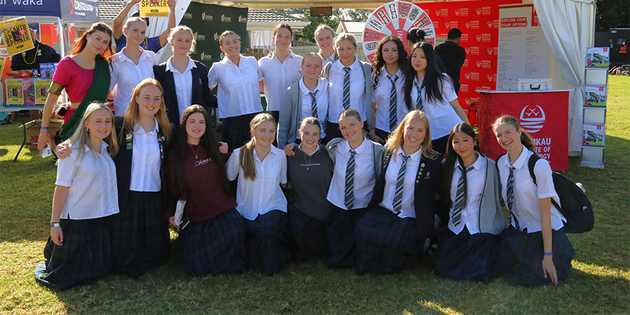 A group of rangatahi in school uniform pose for a photo. 