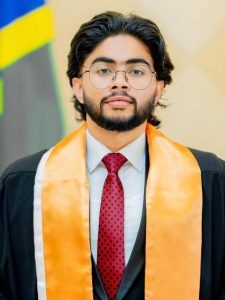 Alandara Mahanam wearing a graduation gown smiles for the camera.