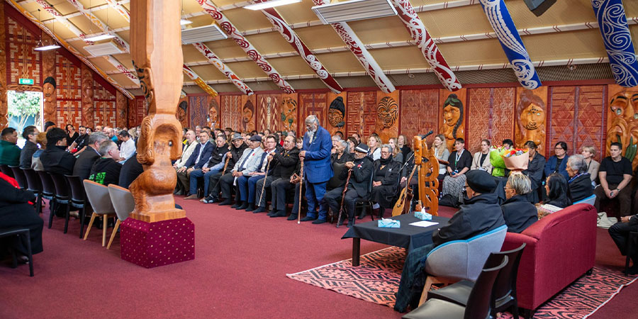 Attendees sit in the marae during the pōwhiri.