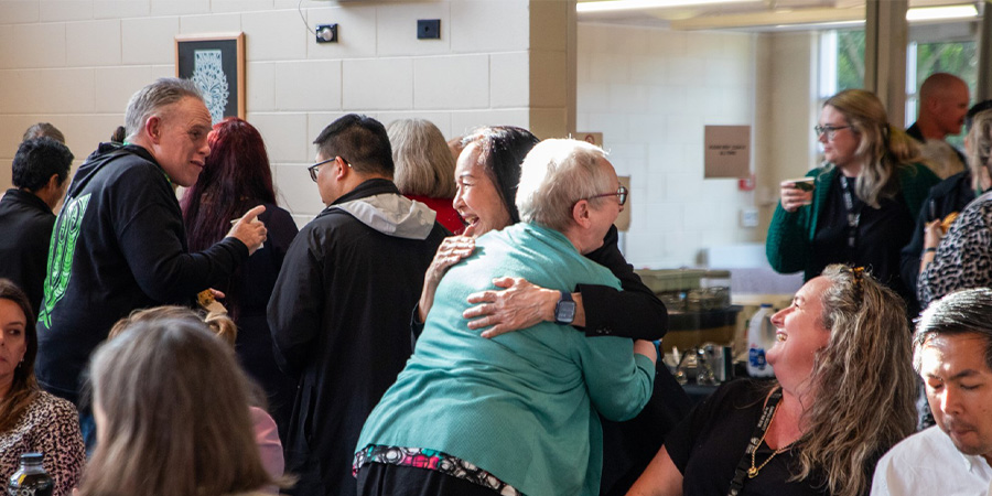 Professor Hong hugs a staff member.