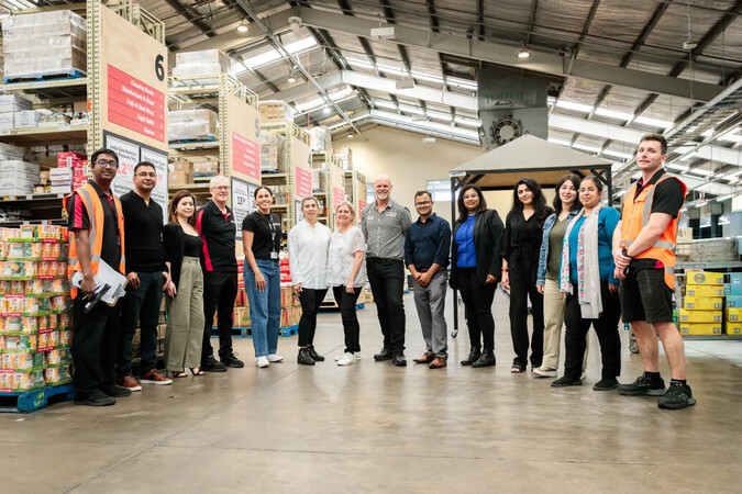 Staff and students smile for the camera inside GIlmour's supermarket.