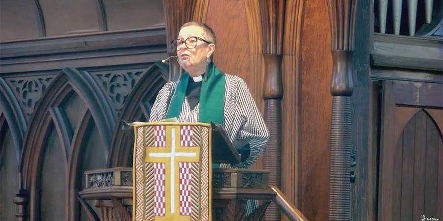 Reverend Deb Cole in priestly attire giving a sermon.
