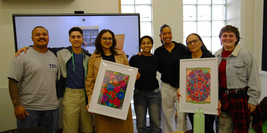 The scholarship winners with pieces of framed art.