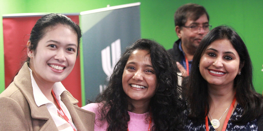 Three attendees smile for the camera.