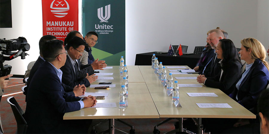 The Chinese delegates and MITU delegates sit at a conference table. 