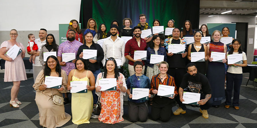 A group of students display their award certificates.
