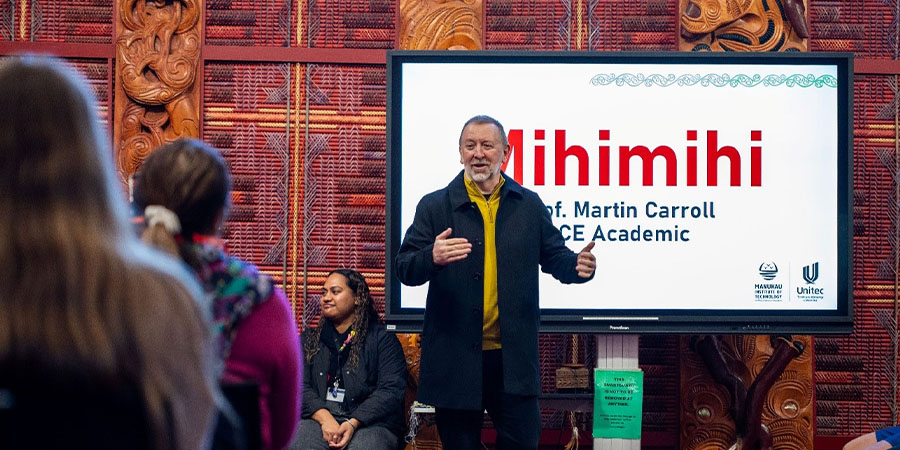 Professor Martin Carroll gives a speech in te wharenui o Te Noho Kotahitanga Marae.