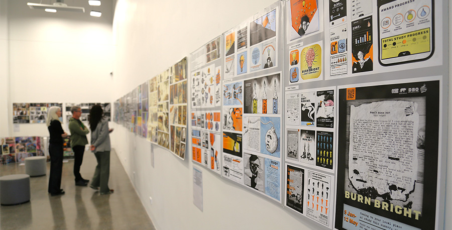 Students look at the art on display in the art exhibition.