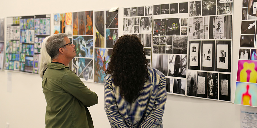Students look at the art on display in the art exhibition.