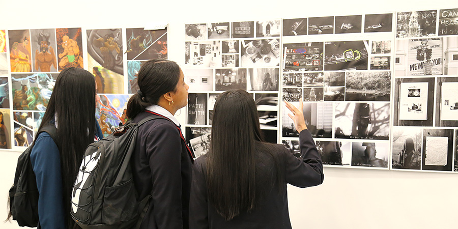 Students look at the art on display in the art exhibition.
