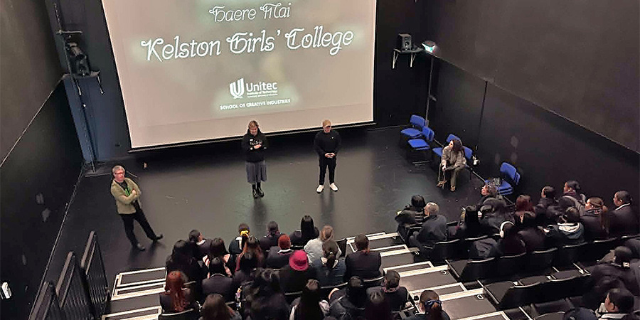 Students sit in a lecture theatre listening to a lecture.
