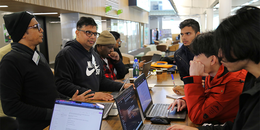 Students busy at work at a table during the hackathon.