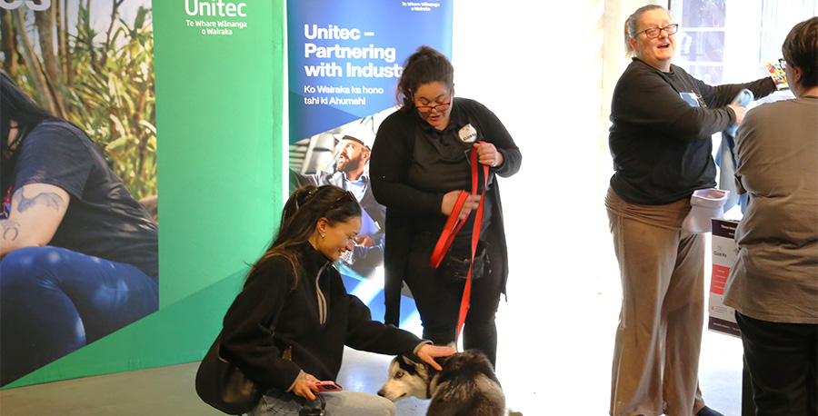 A student pets a dog at the industry connect event.