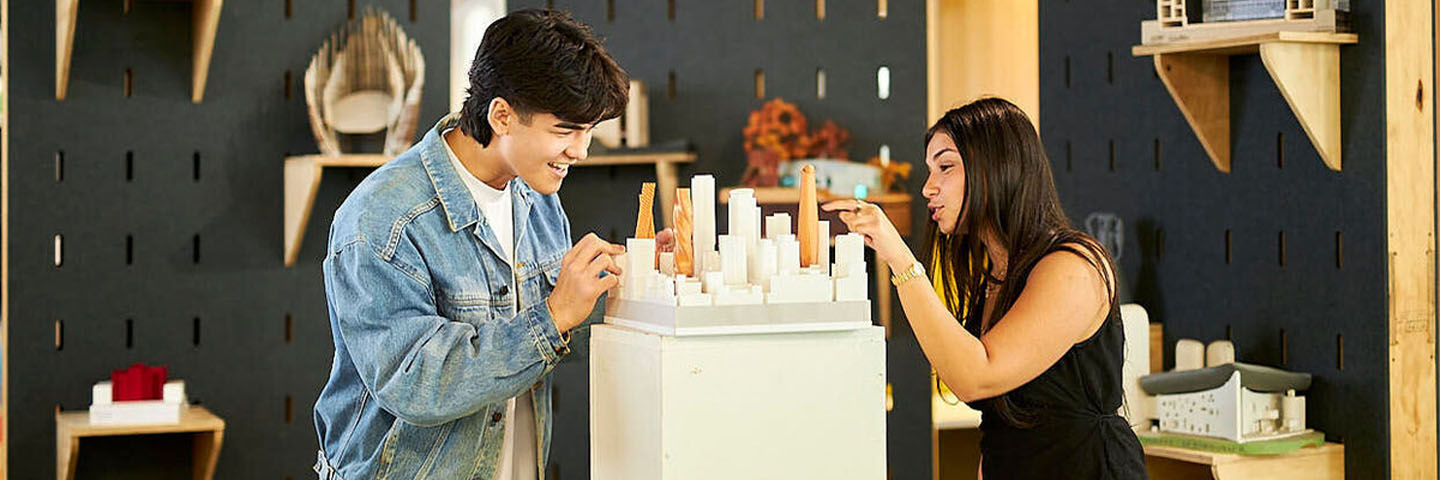 Two students examine an architecture model.