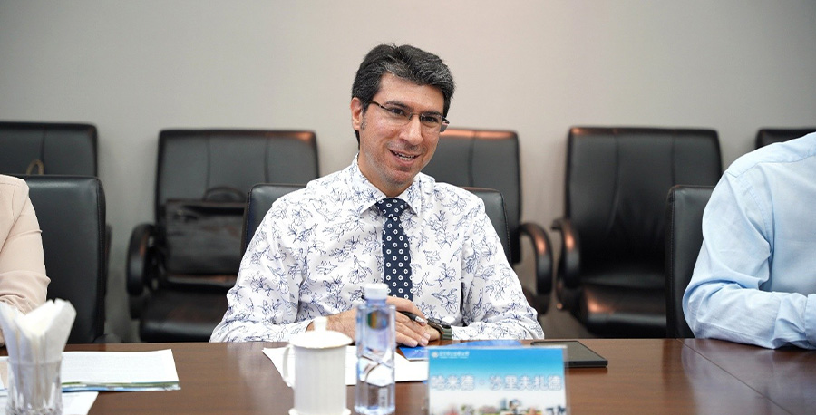 Professor Hamid Sharifzadeh smiles while sitting at a table.