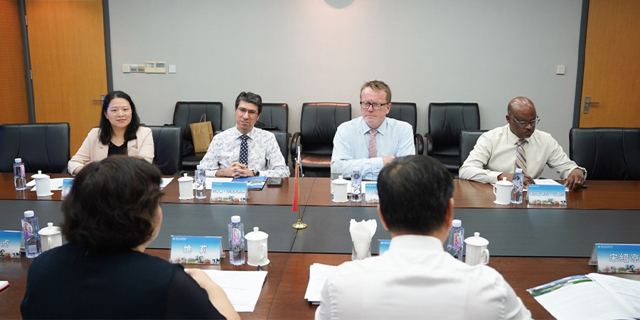 A group of Unitec staff and Shanghai Polytechnic University staff sit around a table having a meeting.