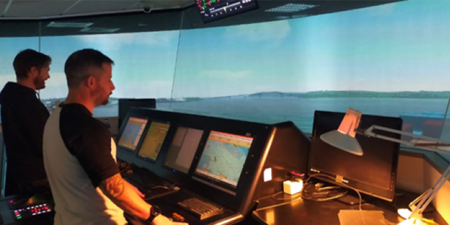 Two students use a maritime simulator.