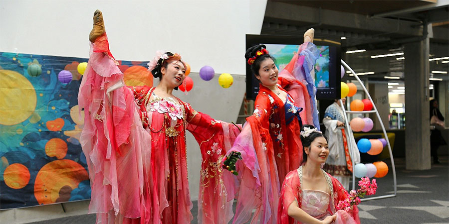 A group of dancers in traditional Chinese dance costumes strike a pose during a performance.