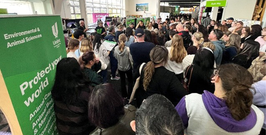 A large crowd of visitors explore booths at Open Day.