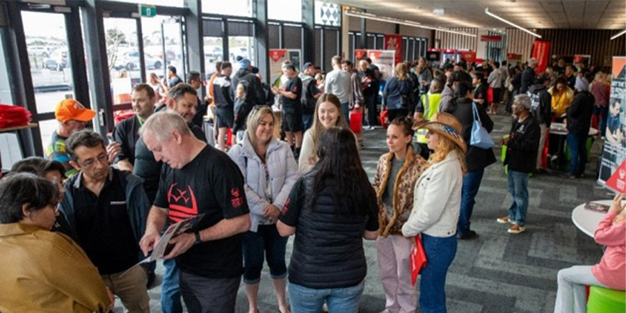 A large crowd of visitors explore booths at Open Day.