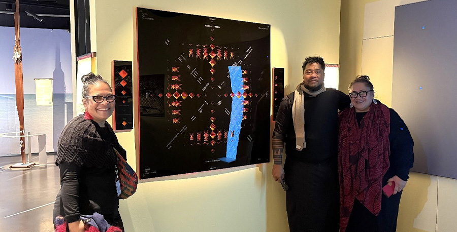 Tavakefai‘ana Sēmisi Fetokai Kulīha‘apai stands with family members next to his collaborative work Kupesi Talatupu'a 'o Tonga - Cosmogram of Tonga.