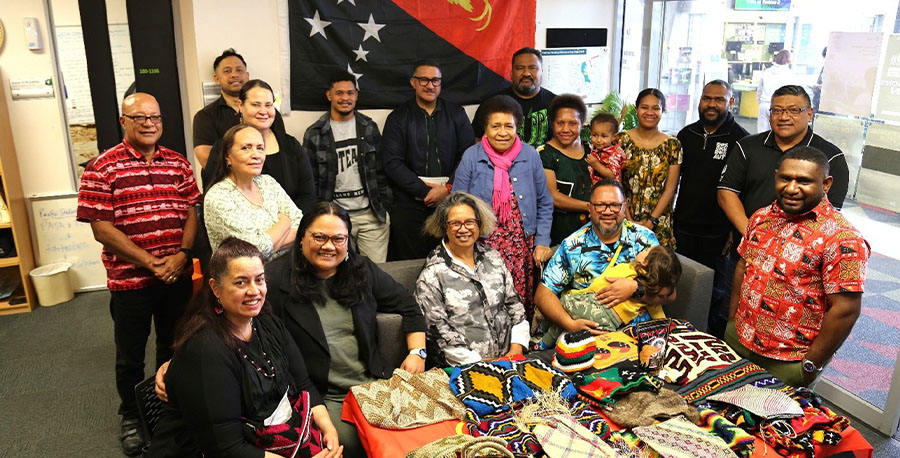 Staff gather around a display of Papua New Guinea crafts.