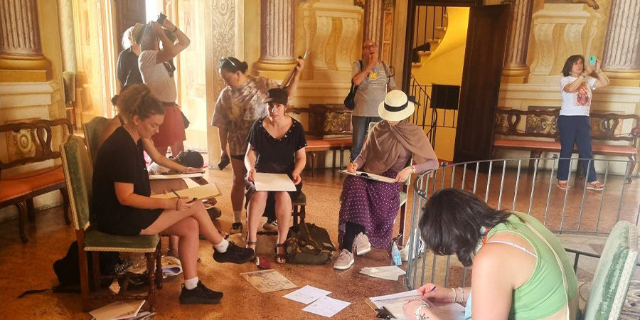 A group of students work in a historic Italian building.